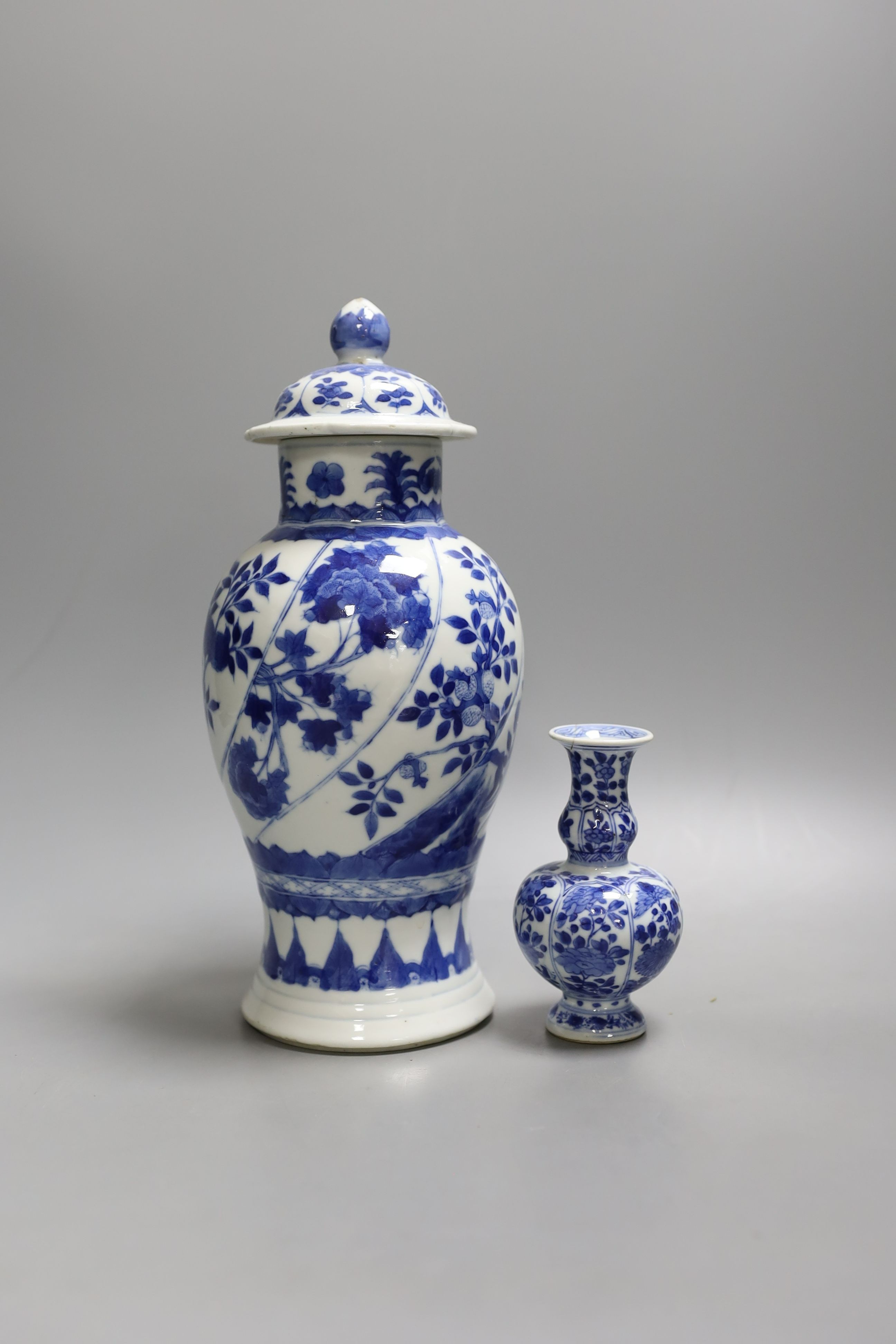 A Chinese blue and white vase and cover, Kangxi mark, 19th century, 26.5cm tall, and a Chinese Kangxi period small vase (2)